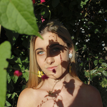 girl's face covered in the shadows of flowers